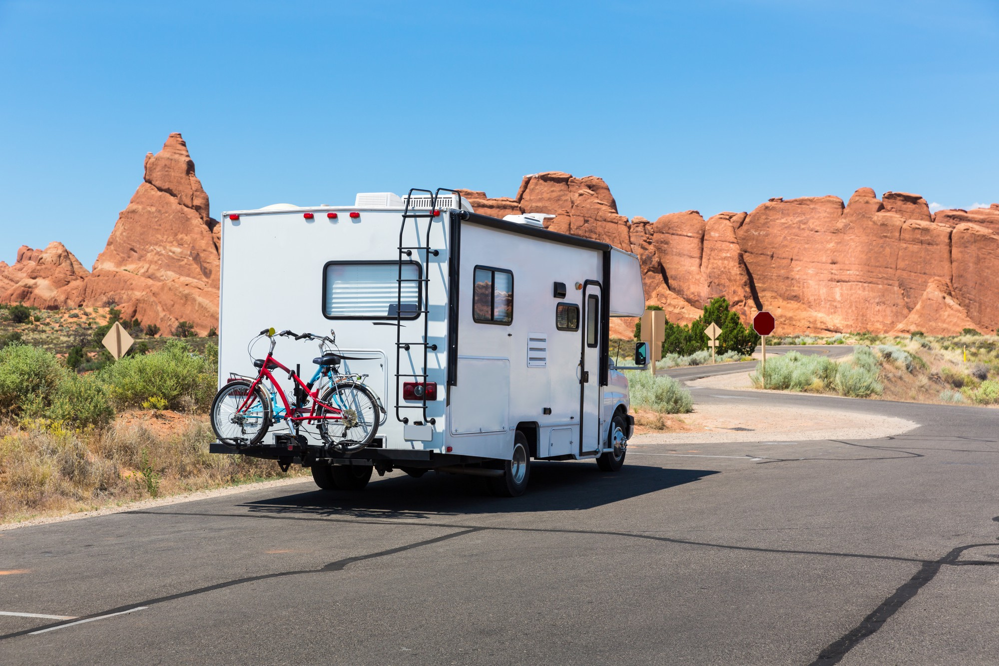 camper-with-bikes-asphalt-road-rocky-mountains-background 2