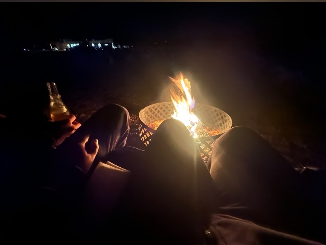 Guests relaxing beside a fire pit at night