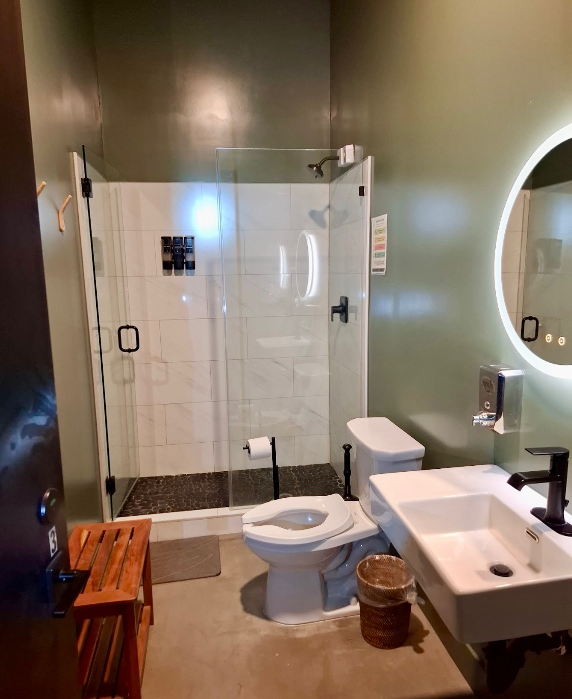 Private bathroom with a glass shower, sink and illuminated vanity mirror