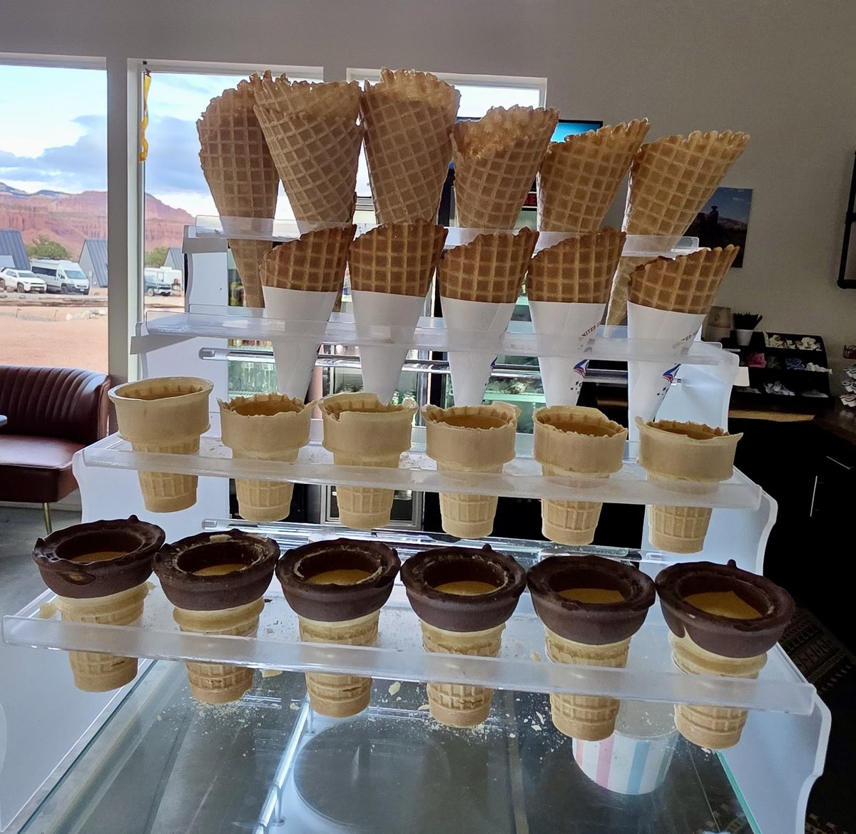 Waffle cones and chocolate-dipped cones on display above the ice cream case