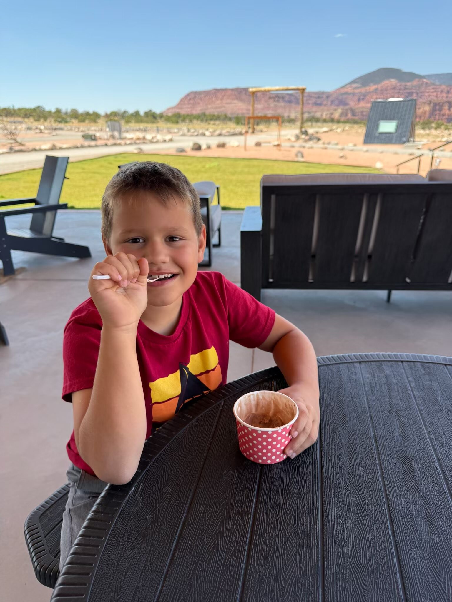 A child enjoying an ice cream cup on the patio